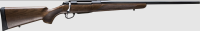 Bolt-action rifle with a wooden stock and long metal barrel, shown in profile.