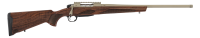 Bolt-action rifle with a walnut stock and long tan barrel, shown in profile in a hunting setup.